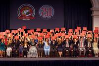 Group picture of scholarship recipients seated on risers on a stage.