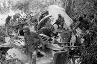 Sandinista soldiers walk amid the debris after shooting down a supply plane of the U.S.-backed rebels in Nicaragua.