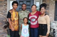 A military family in front of their hoome