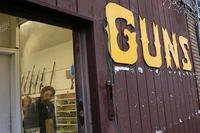 Rifles line a wall above in front of people standing in a gun shop Wednesday, Dec. 19, 2012, in Seattle.