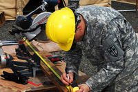 U.S. Army Pfc. Walker Prinz, center, cuts wood at a Monrovia medical unit near Tubmanburg, Liberia, Oct. 24, 2014. (U.S. Army Africa photo by Sgt. 1st Class Will Patterson)
