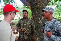 Army Sgt. Richard Mercedes interprets a conversation between Air Force Senior Airman Michael Hyer of the Ohio Air National Guard's 200th Red Horse Civil Engineering Squadron and Cpl. Ramon Burgos of the Dominican Republic’s army.