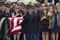 Retired Col. Susan Myers, right, stands with her daughter Amelia Greene and salutes as the casket of her husband, Army Maj. Gen. Harold Greene, is carried by an honor guard during a burial service at, in Arlington, Va. (AP Photo/Evan Vucci)
