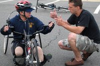 Steve Nardizzi explains the brakes on the handcycle to Elmer Dinglasan, a Navy corpsman participating in the second leg of Soldier Ride 2006, from Washington, D.C., to Camp Lejeune N.C. (Photo by Sgt. Sara Wood)
