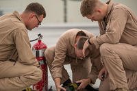 Cpl. Mason Stone, Staff Sgt. David Hoyt, and Cpl. Greg Gambrell set up the refueling site for air delivery ground refueling training. (Cpl. Carlos Cruz Jr./U.S. Marine Corps)