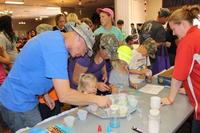 Family members visit the sand art table to make colorful creations during the Month of the Military Child event at Thunder Mountain Activity Centre, Fort Huachuca. (Photo Credit: Gabrielle Kuholski)