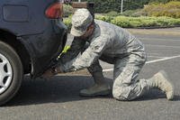 Servicemember near car's rear bumper.
