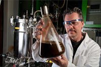 Scientist holding ethanol flask.
