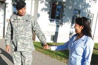 Servicemember and wife holding hands.