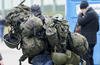 A man carries combat gear as he leaves Poland to fight in Ukraine.