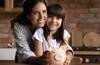 Mother holding daughter who has piggybank