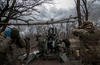 Men from the Black Birds unit of the Ukrainian Territorial Defense Forces fire their M777 Howitzer