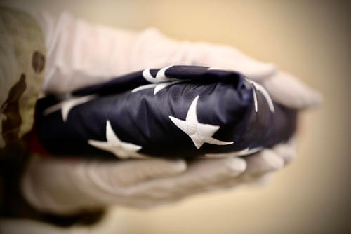 An American flag is presented during a military retirement ceremony.
