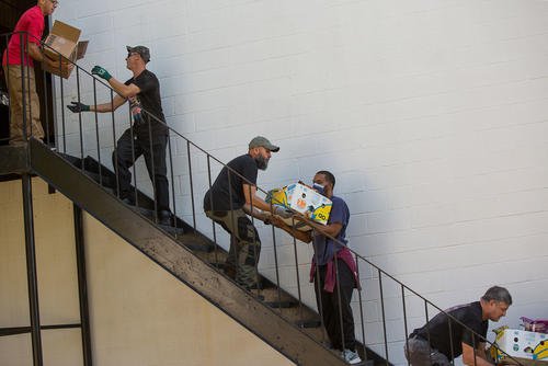 Members of American Legion Post 37 in Norfolk pass food boxes down a stairway