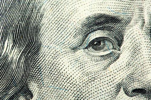 A close-up of Benjamin Franklin's eye, eyebrow, nose, cheek and hair from the U.S. $100 bill.