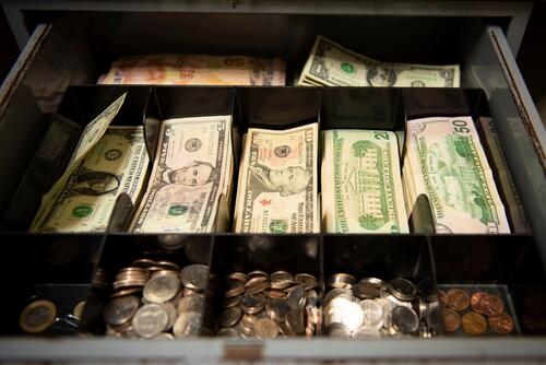 Currency fills a cash box.