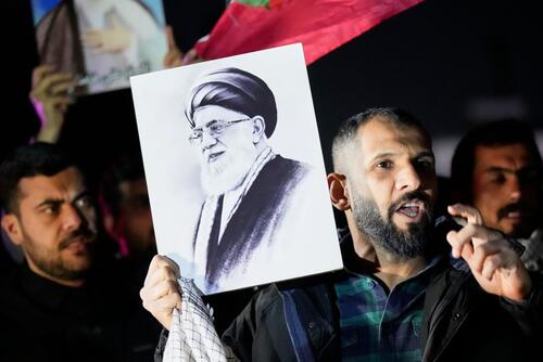 A protester holds a portrait of Iran's Supreme Leader Ayatollah Ali Khamenei.