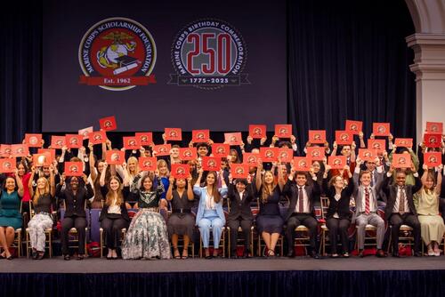 Group picture of scholarship recipients seated on risers on a stage.