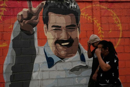 Pedestrians walk past a mural depicting former Venezuelan President Nicolas Maduro in Caracas, Venezuela, Saturday, Jan. 10, 2026, a week after U.S. forces captured him. (AP Photo/Matias Delacroix)